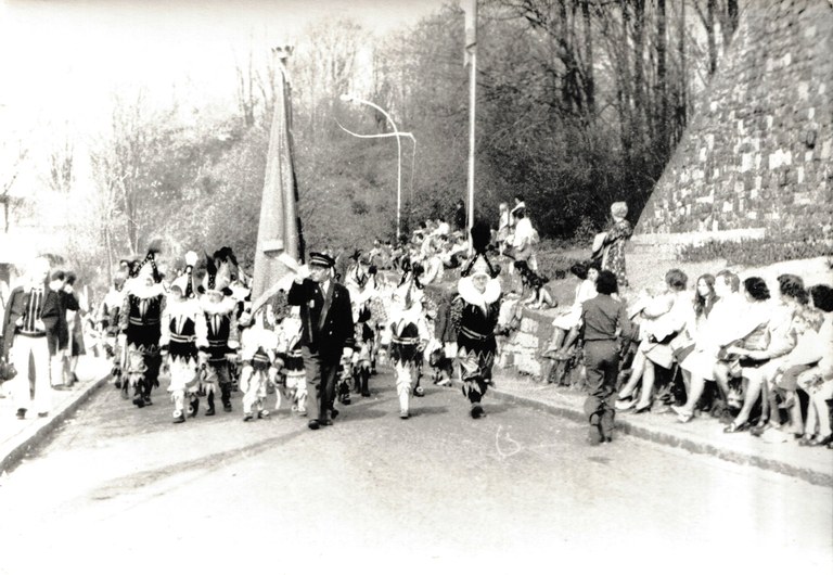 Photographie des Chinels et de leur porte-drapeau lors de leur déplacement à Binche en 1976